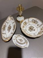 Group shot of handled bowl, oblong dish, stacked bone dishes with trinket dish, and coordinating candlestick holder