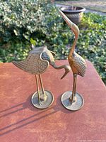 Both brass bird sculptures front view
