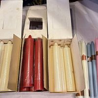 Three boxes of pillar candles and assorted tapers