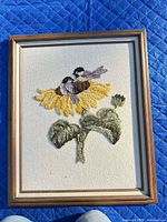Full view of framed crewel embroidery with sunflower and birds