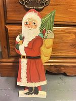 Full view of painted wooden Santa figure standing upright