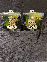 Front view of both sealed Yoda figures in boxes