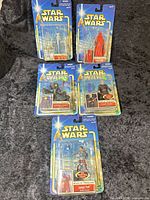Group shot of all five sealed figures on blue card backs