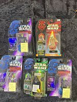 Front view of four packaged figures showing characters and condition