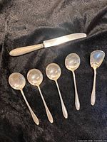 Full view of five teaspoons and one knife
