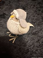 Side view of felted bird showing sweater texture, cap, wings and legs
