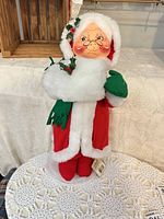 Full view of Annalee Mrs Outdoor Santa figure standing on lace tablecloth
