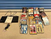 Lot overview showing Sony player, manual, cable and DVDs