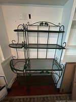 Full view of rectangular baker's rack with side scrolls and mesh shelves
