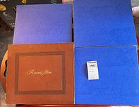 Four binder-style record albums, three blue, one brown
