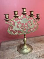 Front view showing five candle cups, ornate backplate, stem and base