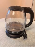 Full view of Elite Gourmet glass kettle on powered base with cord