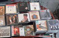 Front angled view of multiple CD stacks showing sample titles and jewel case condition