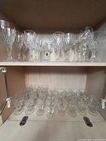 Entire lot on two cabinet shelves showing variety of crystal pieces