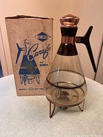 Carafe on stand beside original box