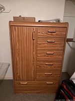 Front view showing five drawers, side cupboard, metal pulls, oak finish