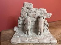 Overall front view of composite sculpture showing figures and wall