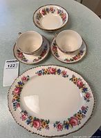 group shot showing all seven china pieces with floral pattern and gold trim