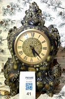 Front view of ornate faux-marble mantel clock showing dial and casing