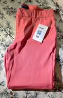 Full view of folded peach/coral Old Navy Pixie pants with MaxSold lot card