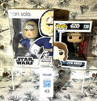 Front view of both boxed figurines side by side