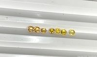 Front view of seven round yellow sapphires lined in row