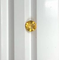 Top view of round yellowish sapphire on white background