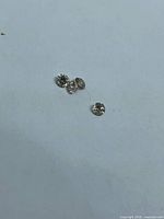 Four loose round diamonds on neutral background