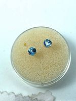 Front view of both sapphire stud earrings in holder
