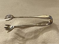 Full view of sterling silver sugar tongs showing claw ends and Birks hallmark