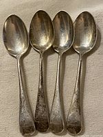 Four Birks sterling teaspoons lined up front view