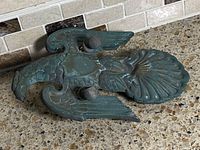 Front view of bronze eagle door knocker showing verdigris patina and overall form
