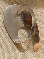 Front view of polished abstract sterling silver brooch