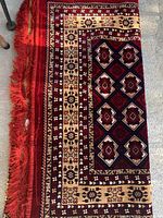 Rolled view of rug showing fringe, border and central pattern