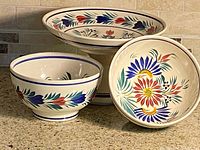 Front view of compote and two bowls showing floral design