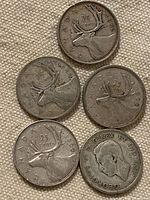 Five Canadian quarters dated 1940-1968, reverse sides showing caribou design