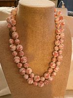 Necklace displayed doubled on bust showing bead pattern and full strand