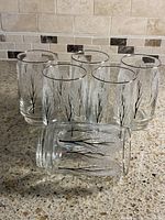 six clear highball glasses on countertop