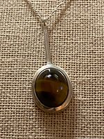 Front view of sterling pendant with tiger’s eye cabochon on chain