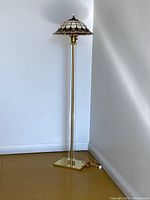 Full view of floor lamp standing against wall