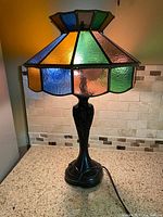 Full view of lamp lit showing shade colors and metal base
