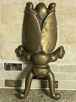 Front view of brass beetle boot jack standing upright