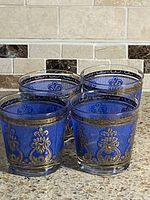 Four blue ribbed lowball tumblers grouped on counter
