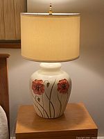 Full view of ceramic lamp with shade on table