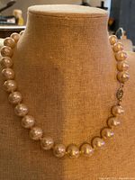Full view of faux pearl necklace on display bust