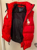 Vest hanging open to show exterior red shell and black lining