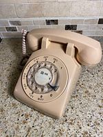 Front angled view of beige Nortel rotary phone showing handset and dial