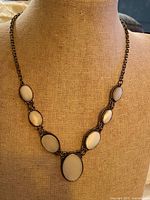 Full view of necklace on display bust showing Y-drop design and chain