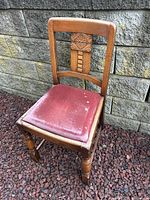 Full view of carved wooden chair showing frame, legs and worn red seat
