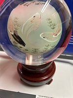 Full view of crystal ball on stand showing koi design